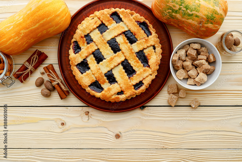 Berry tart pie and orange pumpkin on wooden table Berry tart pie and orange pumpkin on wooden table
