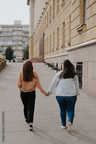 Two young adult lesbian women holding hands. © ShevarevAlex