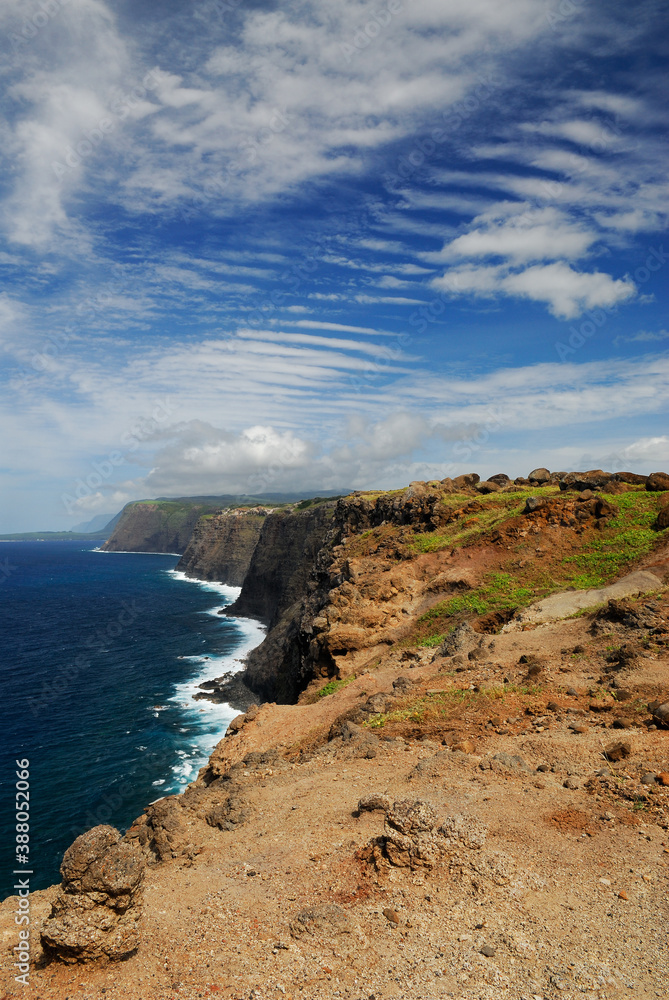 Portrait of north coast Molokai sea cliffs with ripple cloud sky