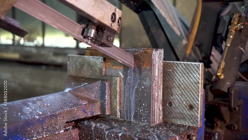 SAWING MACHINE, The band saw for industrial cutting the metal rod and using the coolant in light blue scene.The industrial tool. SAWING MACHINE, The band saw for industrial cutting the metal rod and using the coolant in light blue scene.The industrial tool.