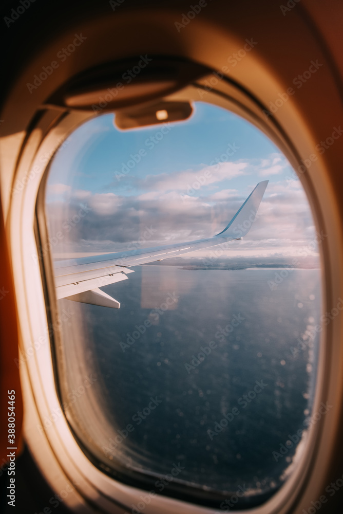 Airplane interior with window view of the Baltic sea and clouds.