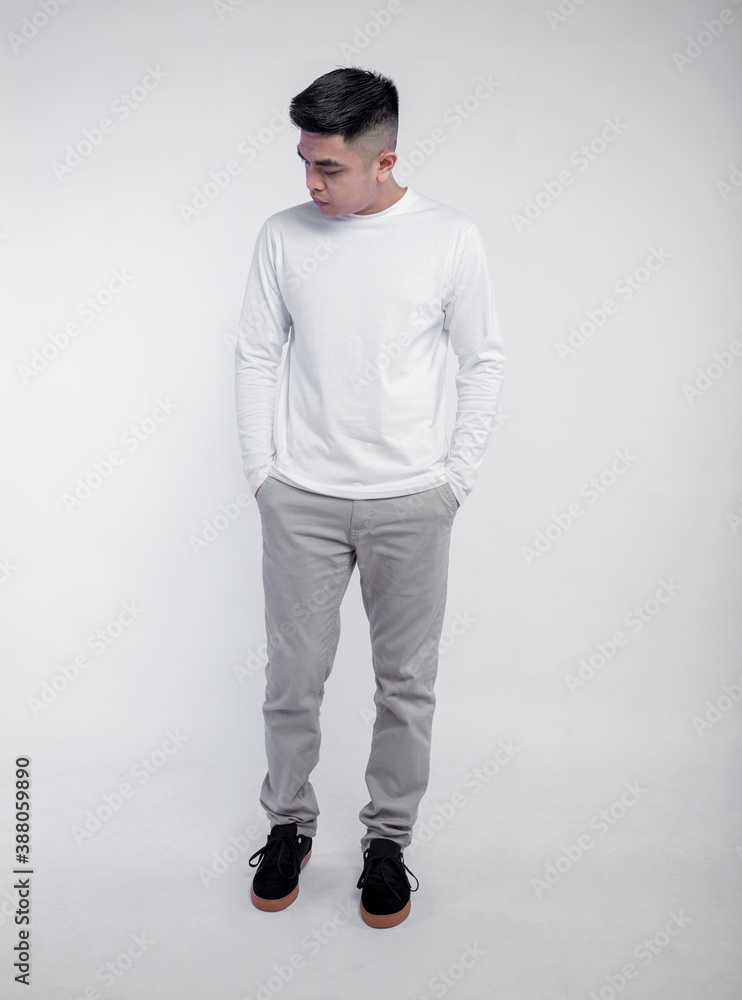 Handsome man posing wearing white long sleeve t shirt isolated on plain background. Handsome man posing wearing white long sleeve t shirt isolated on plain background.