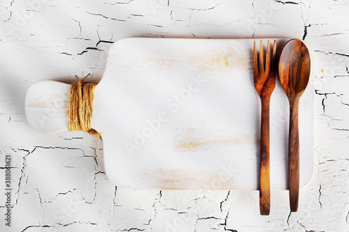 spoon and fork on white wooden chopping board
