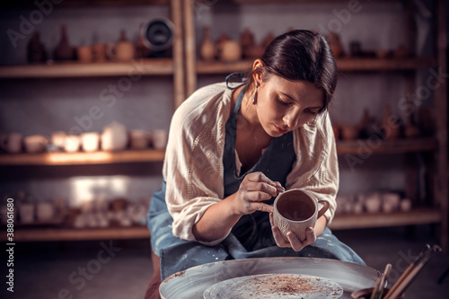 Beautiful handicraftsman making ceramic pottery on wheel. Inspiration and creativity.