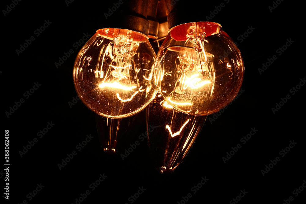 Electric lightbulbs glowing in the darkness Electric lightbulbs glowing in the darkness