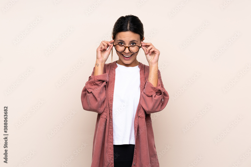 Woman over isolated background with glasses and surprised Woman over isolated background with glasses and surprised