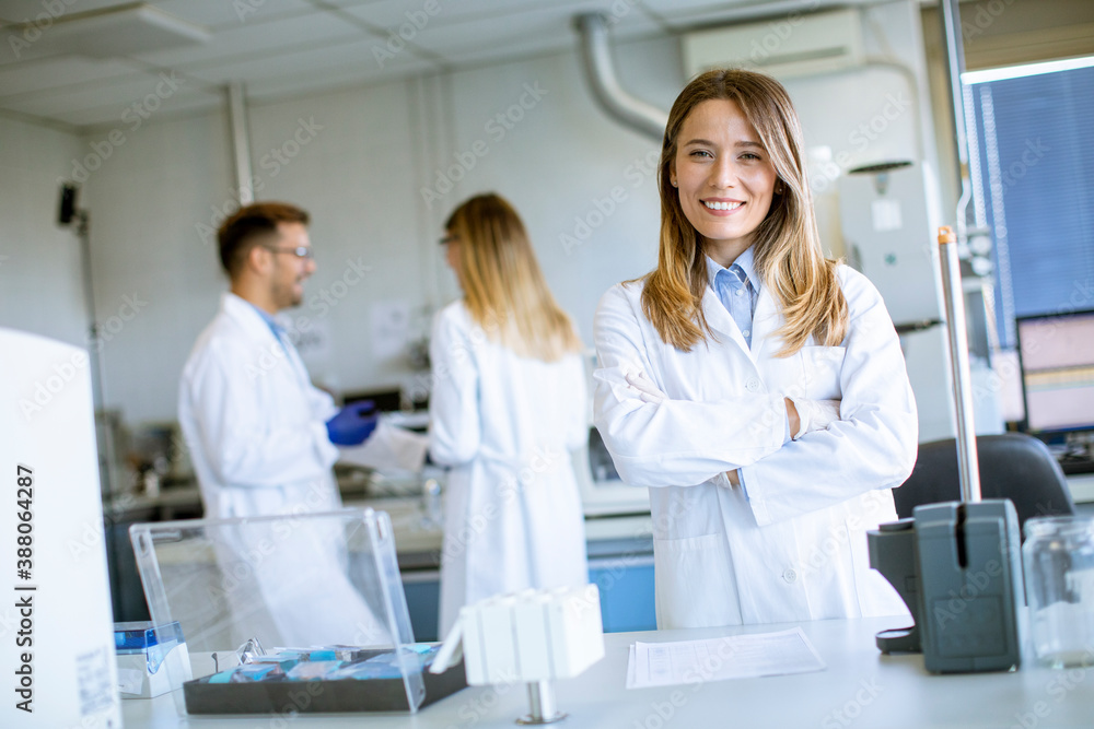 Female scientist in white lab coat standing in the biomedical lab Female scientist in white lab coat standing in the biomedical lab