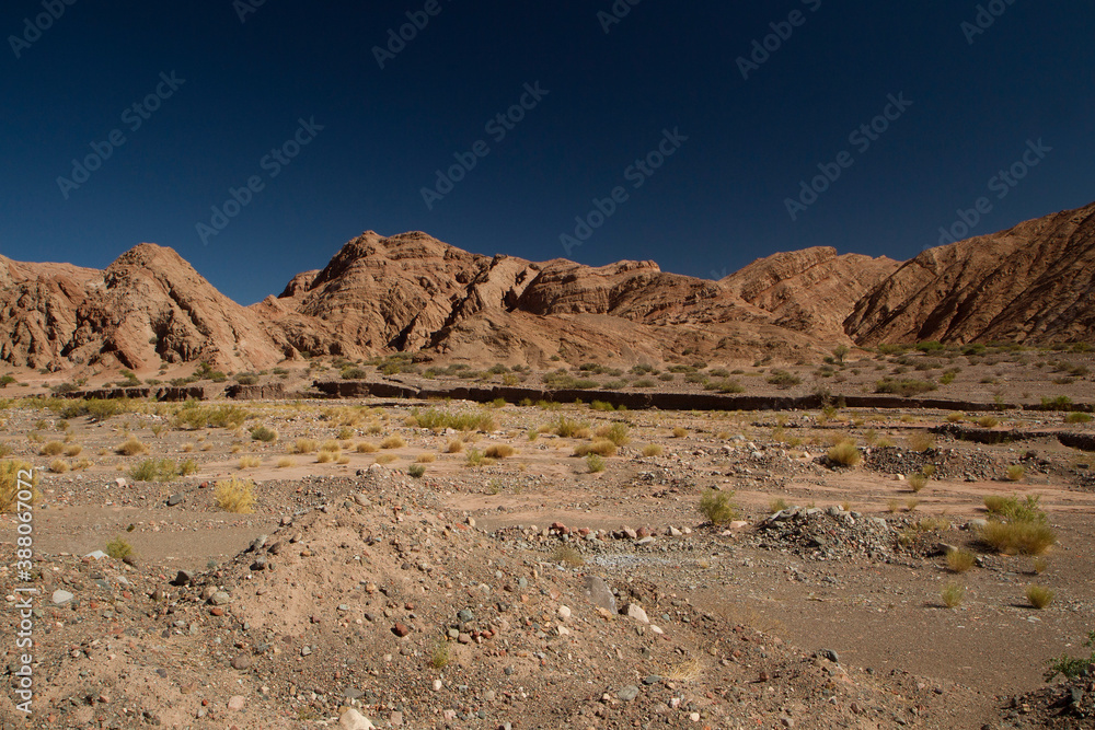The Andes mountain range. View of the desert, sand and brown mountains under a deep blue sky.