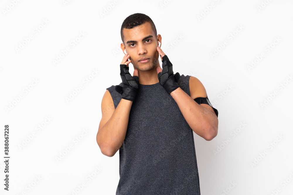 Fototapeta premium Young African American sport man over isolated white background listening music