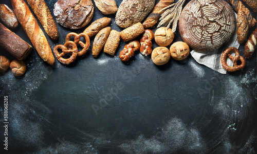 Delicious freshly baked bread assortment on dark rustic background