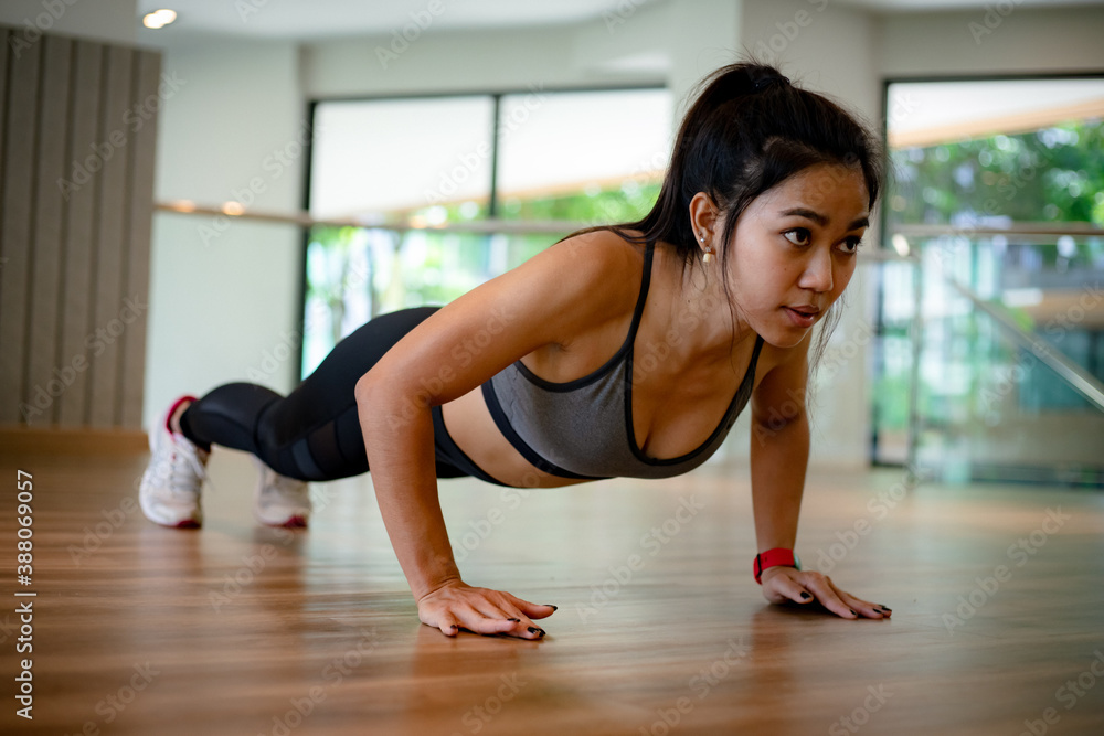 Obraz premium young Asian woman doing push ups in the gym