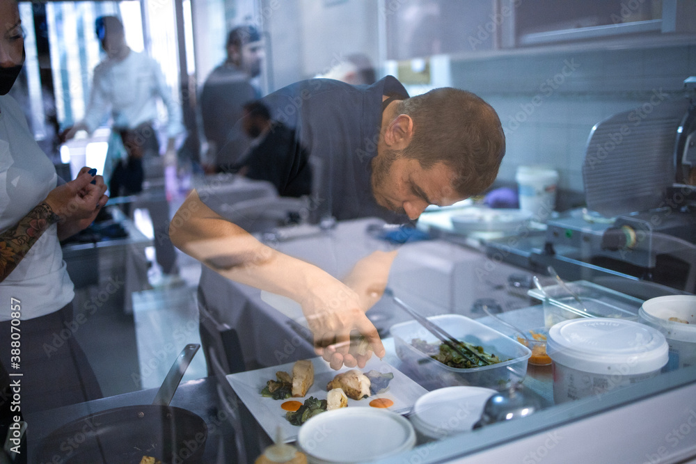Young chef is preparing a typical dish of the restaurant. She brings to the table good and tasty cuisine Young chef is preparing a typical dish of the restaurant. She brings to the table good and tasty cuisine
