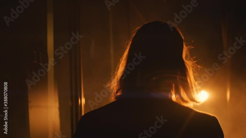 long hair man walks in the spotlight