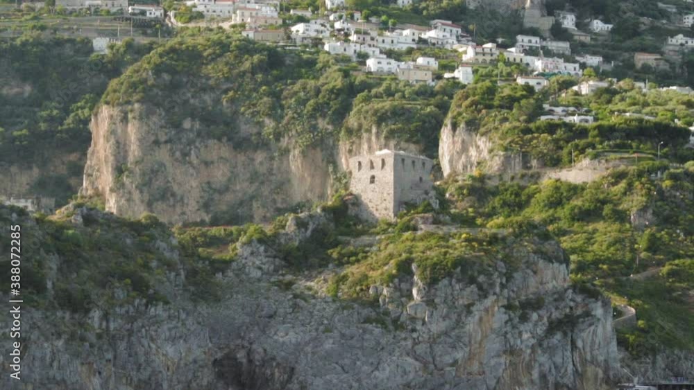 Capo di Conca Watchtower on Amalfi Coast. Mediterranean village in background Capo di Conca Watchtower on Amalfi Coast. Mediterranean village in background