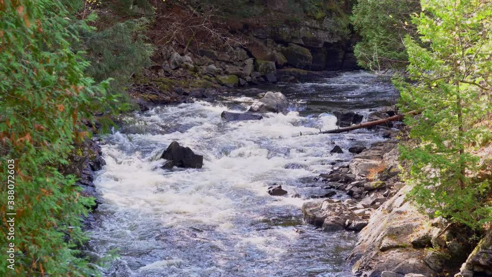 Large boulders part a narrow, winding river passing through a gorge (zoomed). Large boulders part a narrow, winding river passing through a gorge (zoomed).