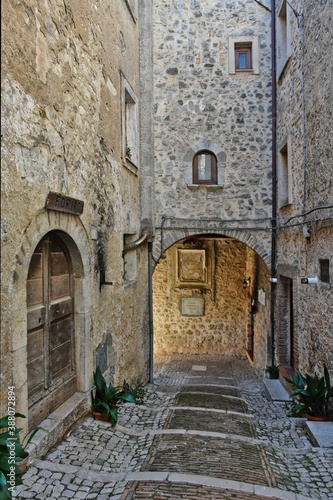 Fototapeta Naklejka Na Ścianę i Meble -  A narrow street among the old stone houses of Castro dei Volsci, a medieval village in the province of Frosinone in Italy.