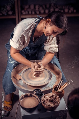 Charming ceramist master at his wheel creating a new masterpiece. Concept for woman in freelance, business, hobby. photo