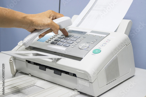 Canvastavla hand man are using a fax machine in the office, equipment for data transmission
