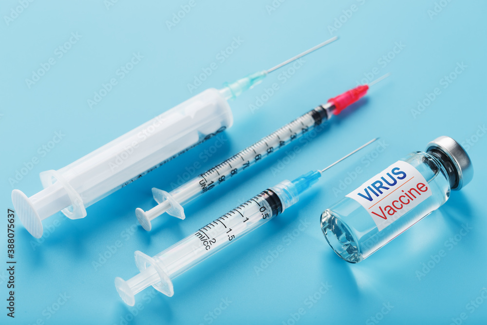 A set of ampoules and syringes with the inscription Virus vaccine and a set of syringes on a blue background. A set of ampoules and syringes with the inscription Virus vaccine and a set of syringes on a blue background.