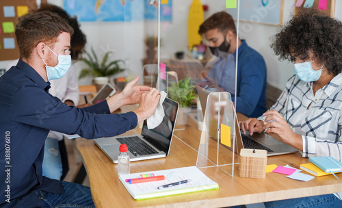 Obraz na plátně Coworking office with multiracial people wearing surgical face mask - Young man