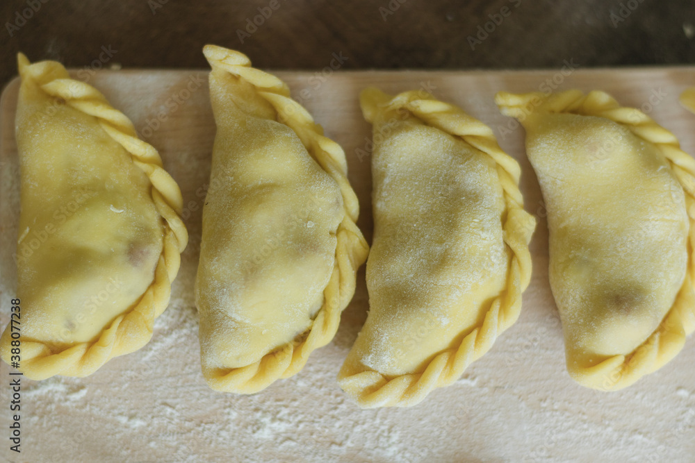 Dumplings with different fillings on a floured board. Homemade food close-up Dumplings with different fillings on a floured board. Homemade food close-up