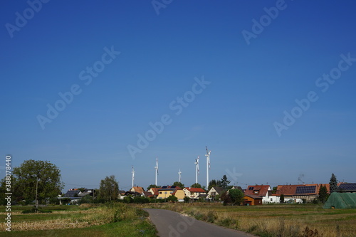 view of wind turbines above village