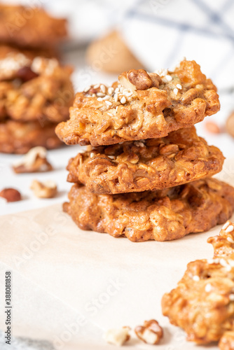Homemade oat cookies with various nuts and sesame seeds close-up. Tasty and healthy dessert, vegetarian and vegan food.