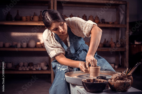 Charming female master demonstrates the process of making ceramic dishes using the old technology. Craft manufacture.
