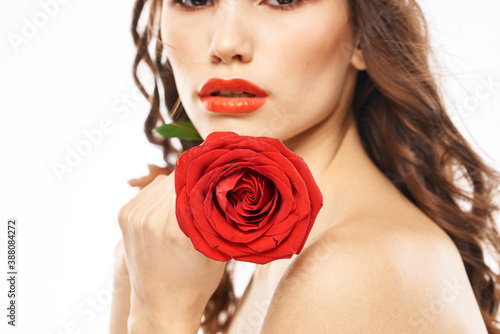 Woman with naked shoulders and red rose evening makeup light background