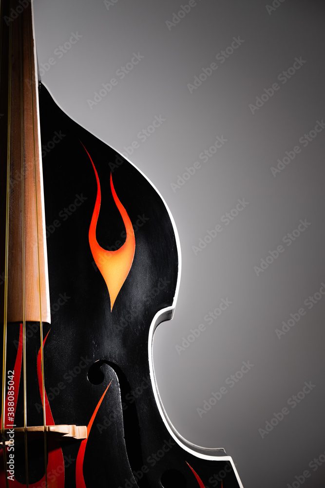 Acoustic double bass with flames decals, closeup view. Rock'n'roll