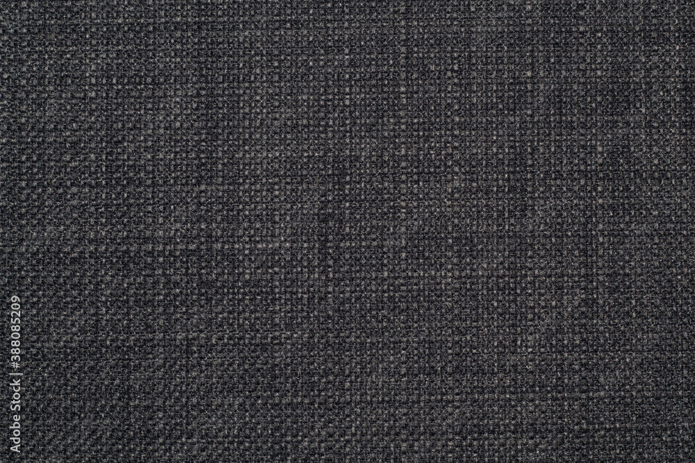 The background is a rough, dense linen fabric with a distinct braid weaving in black and gray shades. The background is a rough, dense linen fabric with a distinct braid weaving in black and gray shades.