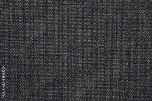 The background is a rough, dense linen fabric with a distinct braid weaving in black and gray shades.