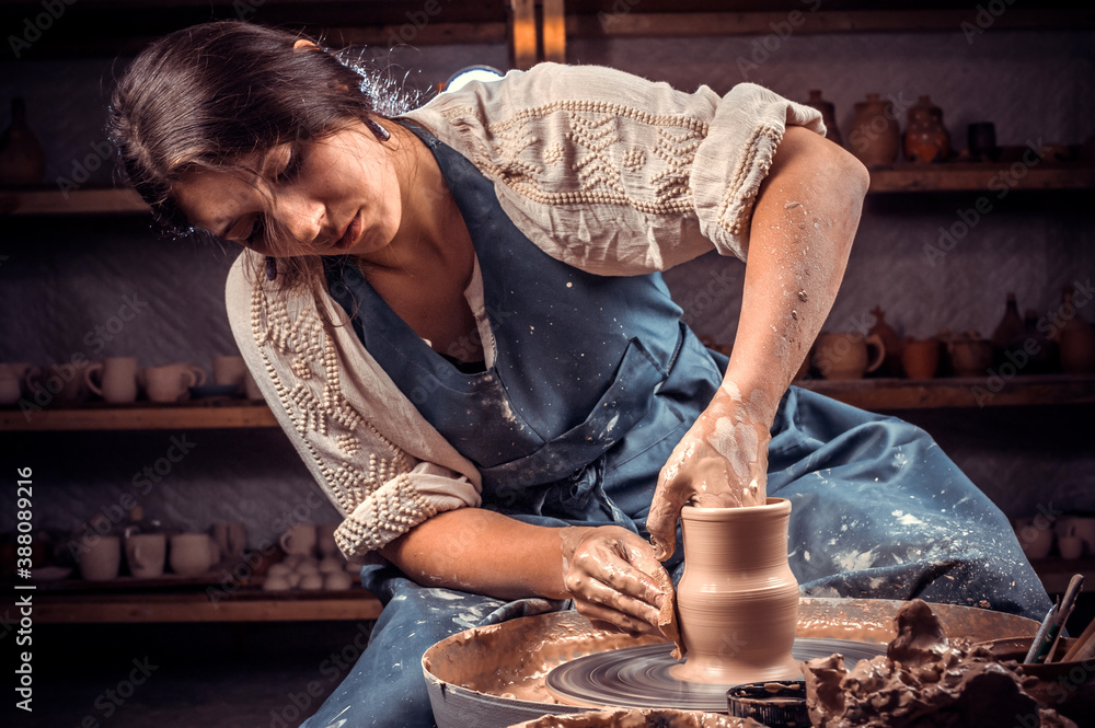 Charming pottery master making ceramic pottery on wheel. Handcraft. - obrazy, fototapety, plakaty 