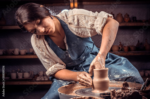 Charming pottery master making ceramic pottery on wheel. Handcraft. photo