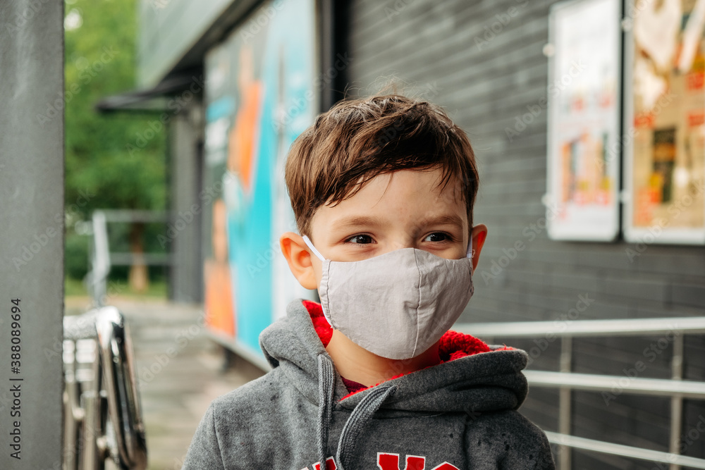 A boy in a protective mask enters the supermarket. Protecting a child from covid-19 coronavirus in a supermarket. A boy in a protective mask enters the supermarket. Protecting a child from covid-19 coronavirus in a supermarket.