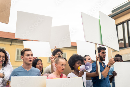 Public demonstration on the street against social problems and human rights. Group of multiethnic people making public protest