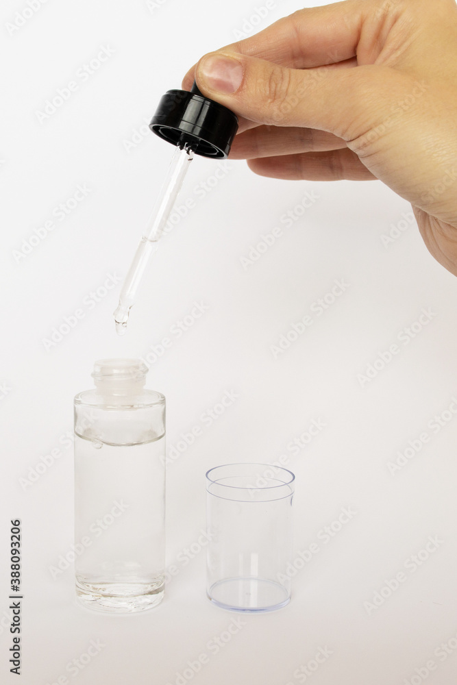 Dropper glass Bottle Mock-Up. Сosmetic pipette on white background. Oily drop falls from cosmetic pipette on white background Dropper glass Bottle Mock-Up. Сosmetic pipette on white background. Oily drop falls from cosmetic pipette on white background