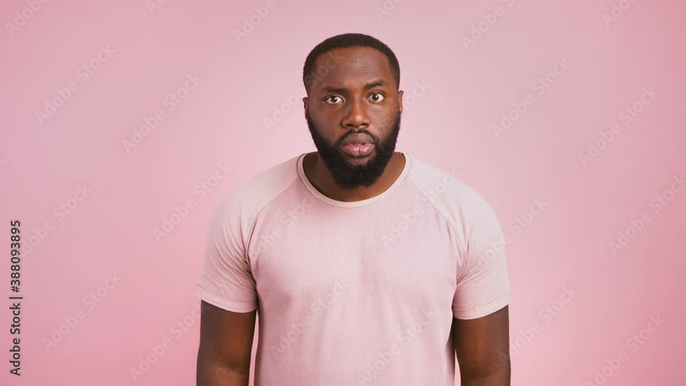 Mystery, silence, secret concept. Suspicious african american man showing hush gesture, putting finger on lips Mystery, silence, secret concept. Suspicious african american man showing hush gesture, putting finger on lips