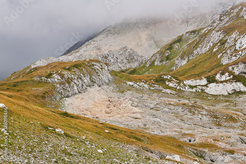 alpine herbaceous foggy landscape with stone fields in place of melted glaciers