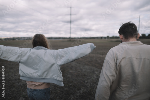 a couple in love walks in an open soybean field in the evening in cloudy weather