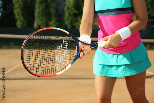 Sportswoman playing tennis at court on sunny day, closeup © New Africa