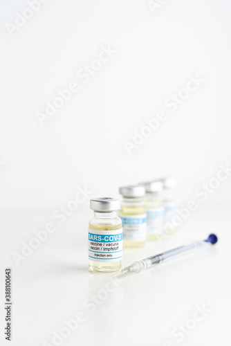 coronavirus vaccine and syringe, defocused white background