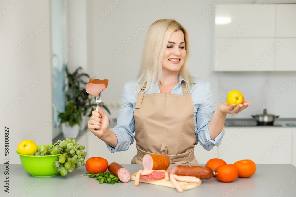 woman holds and chooses between meat and apple