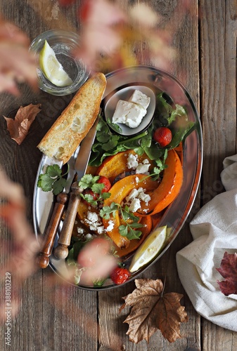 Oven baked pumpkin with feta cheese and spinach. Overhead view photo