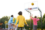 slam dunk. young caucasian basketball players, boys throwing ball into basketball hoop at playground. summer days, holidays