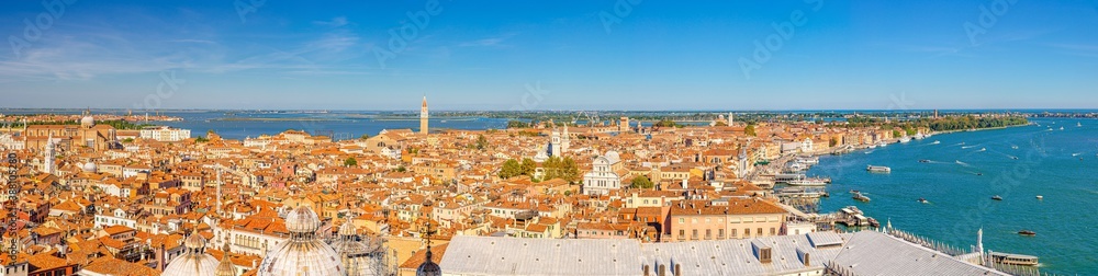 Aerial panoramic view of Venice city old historical centre, buildings with red tiled roofs, churches, bell towers and islands background, Veneto Region, Northern Italy. Amazing Venice cityscape.