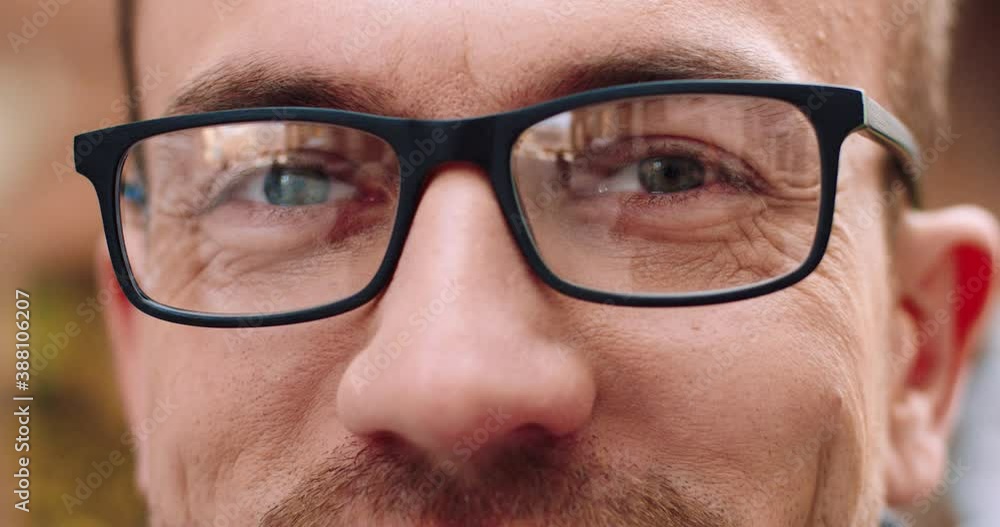 Close up of handsome eyes in glasses of European man looking at camera. Man smiles with his eyes. Close up of handsome eyes in glasses of European man looking at camera. Man smiles with his eyes.