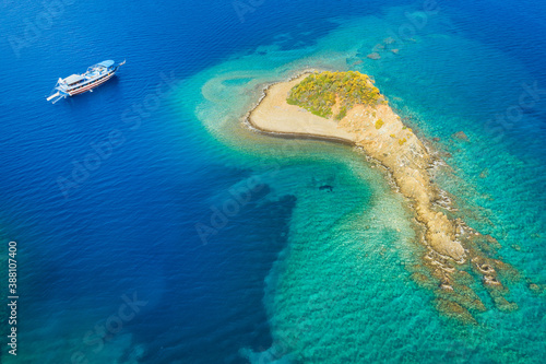 aerial view to little sand island with alone boat at sea and with copy space