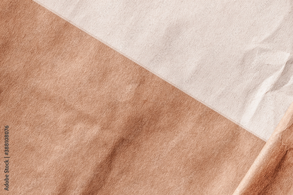 Wrinkled crumpled cardboard surface of two shades. Brown ang beige rough paper texture background, copy space