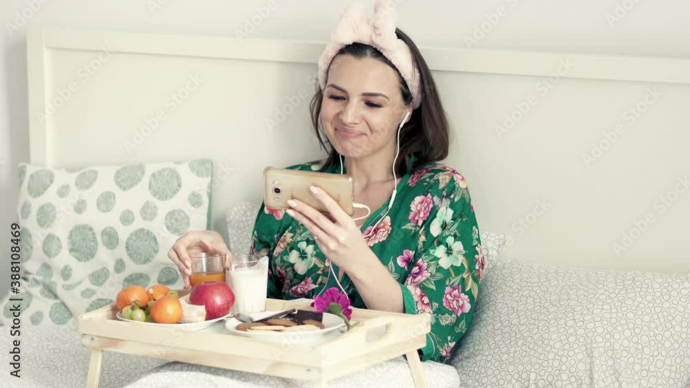 Young, happy woman watching movie on smartphone on bed at home, 4K
Young, happy woman watching movie on smartphone on bed at home, 4K